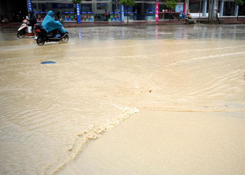 Motorbikes wade through a flooded street in Wuyuan county, East China's Jiangxi province on May 13, 2010. [Xinhua]