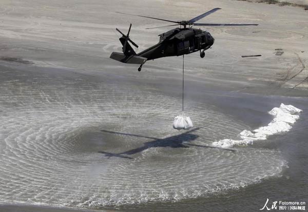 A U.S. aircraft airdrops sandbags to prevent the spilled oil from further spreading as the oil was seen floating on the surface of the sea off the coast the gulf of Mexico, on May 11, 2010. The 'Deepwater Horizon' drilling rig, owned by Swiss-based Transocean and leased by BP, sank April 22 some 52 km off Venice, Louisiana, after burning for roughly 36 hours. The untapped wellhead continues gushing oil into the Gulf of Mexico. 