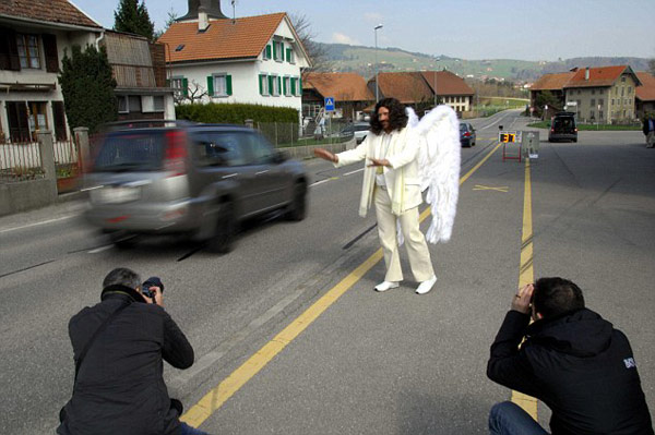 Slow down: The road safety angel gets to work in Fribourg, waving at motorists who are travelling too fast.