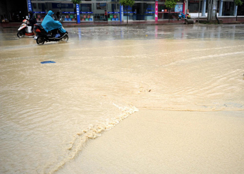 Motorbikes wade through a flooded street in Wuyuan county, east China's Jiangxi province on May 13, 2010. 