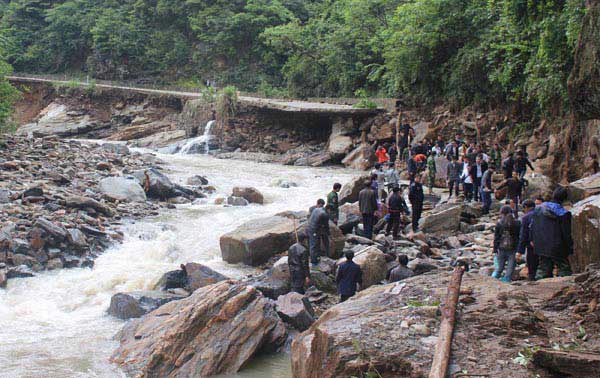 People mend the road destroyed by the strong rainfall in Fengjia Town of Xinhua County, Loudi City, central China's Hunan Province, May 8, 2010. 