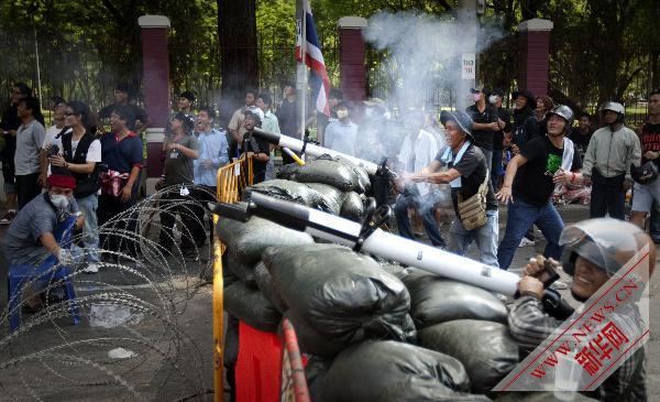 Smoke fills the air as anti-government 'red shirt' protesters, who created a barricade near a military checkpoint, use a makeshift launcher to shoot fireworks towards army soldiers in Bangkok May 14, 2010.