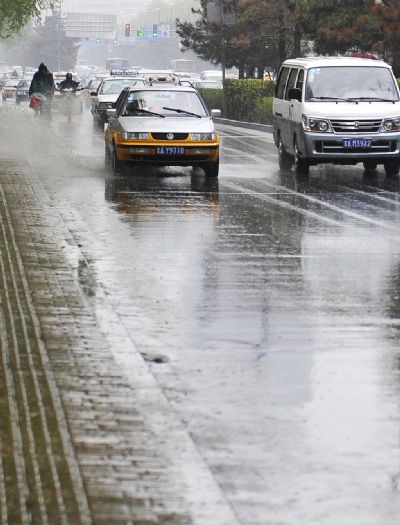 Vehicles drive in the rain in Changchun, capital of northeast China's Jilin Province, May 15, 2010. Changchun witnessed a torrential rainfall Saturday. 
