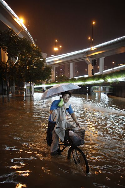 A man rides in floods in Guangzhou, capital of south China's Guangdong Province, May 14, 2010. A rainstorm poured into Guangzhou Friday night, which flooded parts of the urban area in the city. 