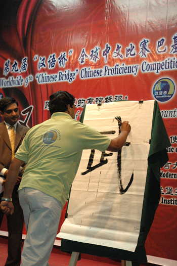 A contestant demonstrates his skill in Chinese calligraphy during a preliminary round of the 9th 'Chinese Bridge' proficiency contest at the National University of Modern Languages in Islamabad, capital of Pakistan, on May 14, 2010. [Yan Zhonghua/Xinhua]