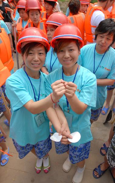 A pair of twin sisters cheer up each other before taking part in a torrent drifting game in Yuxi Valley in Lushi County, central China's Henan Province, May 15, 2010. More than 1,000 twins from all over the country took part in the 4th torrent drifting game for twins here on Saturday. (Xinhua/Yan Ruipeng)