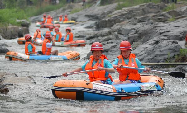 Twins players take part in a torrent drifting game in Yuxi Valley in Lushi County, central China's Henan Province, May 15, 2010. More than 1,000 twins from all over the country took part in the 4th torrent drifting game for twins here on Saturday. [Xinhua/Yan Ruipeng] 