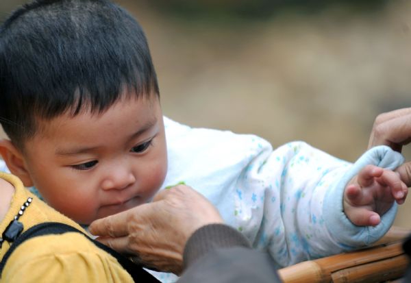 A child plays with his mother after a flood in Zhuxi village of Xupu County in Huaihua City, central China&apos;s Hunan Province, May 16, 2010. Heavy rains triggered mountain torrents in Xupu County on Wednesday and Thursday, causing damage to its four major bridges and the trunk roads linking Shanxi Town to the outside. [Xinhua]