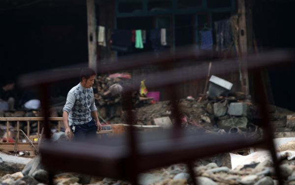 A residents search in the rubble after a flood in Zhuxi village of Xupu County in Huaihua City, central China&apos;s Hunan Province, May 16, 2010. Heavy rains triggered mountain torrents in Xupu County on Wednesday and Thursday, causing damage to its four major bridges and the trunk roads linking Shanxi Town to the outside.[Xinhua] 