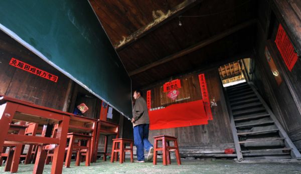 Residents install a blackborad in a makeshift school after flash floods in Zhuxi village of Xupu County in Huaihua City, Hunan Province, May 16, 2010. Heavy rains triggered flash floods in Xupu County on Wednesday and Thursday, causing damage to its major bridges and trunk roads. 