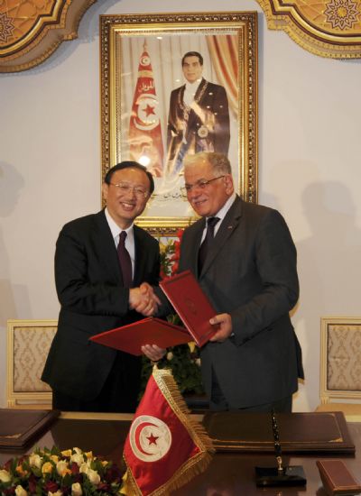 Chinese Foreign Minister Yang Jiechi (L) shakes hands with Tunisian Foreign Minister Kamel Morjane after a signing ceremony in Tunis, May 17, 2010. [Kang Xinwen/Xinhua]