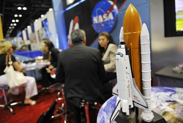People talk business at the Kennedy Space Center pavilion during the 2010 International POW WOW at the Orange County Convention Center in Orlando, Florida, the United States, May 17, 2010. [Xinhua/Zhang Jun]