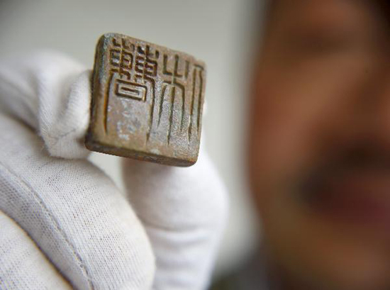 Photo taken on May 14, 2010 shows an unearthed bronze seal with Cao Xiu's name found at the tomb of Cao Xiu, a noted general from the Three Kingdoms period (220-280 A.D.) in Mangshan of Luoyang City, central China's Henan Province. Archeologists of Henan provincial cultural heritage bureau confirmed that they have founded the tomb of Cao Xiu during the tomb excavation in Mengjin County of Luoyang City at a press conference on Monday. [Xinhua photo]