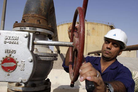 A worker operates valves at the Rumaila oil refinery, near Basra, Iraq. 