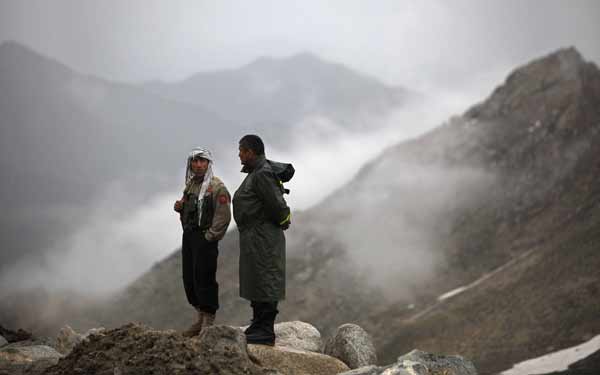 Afghan security personnel are on standby near the mountains where an Afghan Pamir Airways plane is believed to have crashed in the Salang pass May 17, 2010.