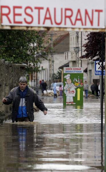 A local man walks home in the floodwaters of the Vadasz stream in Szikszo, in north-east Hungary, about 200 kms from Budapest on May 17, 2010 after heavy rainfalls and flood hit Hungary.