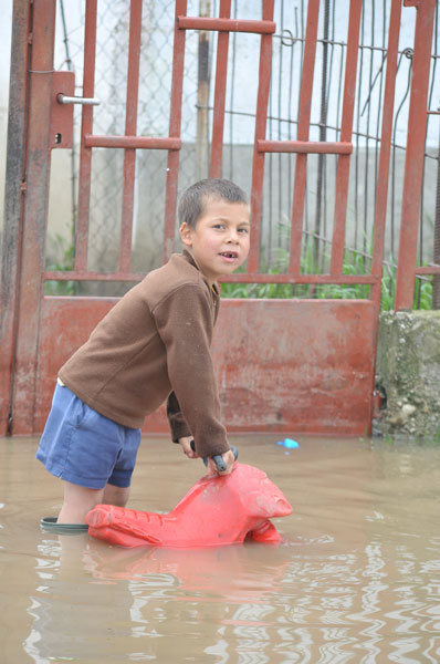 A boy plays in front of his flooded house in Boldva village , some 200 kms northeast from Budapest, capital of Hungary, May 17, 2010. Heavy rainfalls and floods hit the country last weekend, forcing more than 2,000 inhabitants to leave their homes.