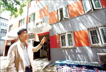 Chen Jialong, professor at Beijing University of Civil Engineering and Architecture, shows a building which was built of recycled concrete and bricks. [China Daily] 
