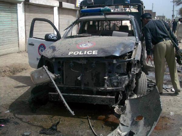 A policeman inspects a damaged vehicle at the blast site in northwest Pakistan's Dera Ismail Khan, May 18, 2010. At least 12 people were killed and 15 injured in the bomb attack targeting a police vehicle on Tuesday.