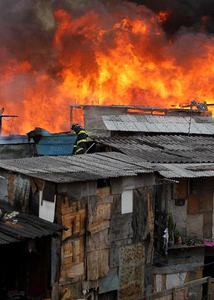 Firefighters try to put out the fire in the favela Naval of Diadema in Sao Paulo State, Brazil, May 18, 2010. The fire starting at around 2:30 pm on Tuesday covered an area of 1,000 square meters. There has been no casualty report. 