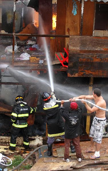 Firefighters try to put out the fire in the favela Naval of Diadema in Sao Paulo State, Brazil, May 18, 2010. The fire starting at around 2:30 pm on Tuesday covered an area of 1,000 square meters. There has been no casualty report. 