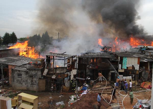 Firefighters try to put out the fire in the favela Naval of Diadema in Sao Paulo State, Brazil, May 18, 2010. The fire starting at around 2:30 pm on Tuesday covered an area of 1,000 square meters. There has been no casualty report.