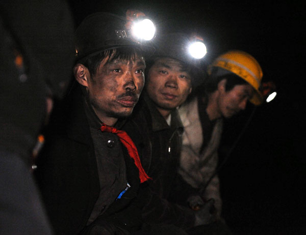 Three miners are anxiously waiting outside a coal mine of Chentong Coal Industry Co., Ltd. in Yuxian County, Shanxi Province, May 19, 2010. They want to learn what has happened to their co-workers. A gas explosion happened to the mine on May 18, killing at least 10 people. One miner is still missing. 