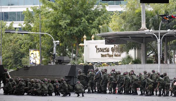 Thai troops and an armoured vehicle take up their positions on a deserted road at the entrance of the business district during a rally by anti-government 'red shirt' protesters in Bangkok May 19, 2010.