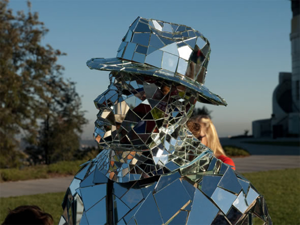 A silver Mirror Man cladded with 1,000 fragments of glass appears in front of the Griffith Observatory of Los Angeles, US, May 19, 2010. 