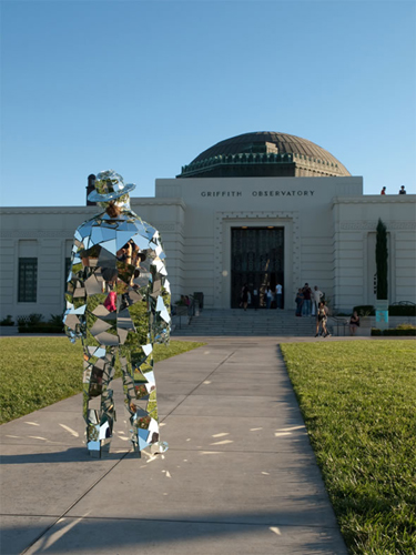 A silver Mirror Man cladded with 1,000 fragments of glass appears in front of the Griffith Observatory of Los Angeles, US, May 19, 2010.