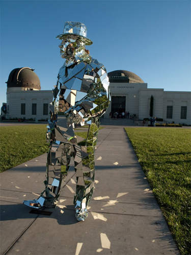 A silver Mirror Man cladded with 1,000 fragments of glass appears in front of the Griffith Observatory of Los Angeles, US, May 19, 2010. 