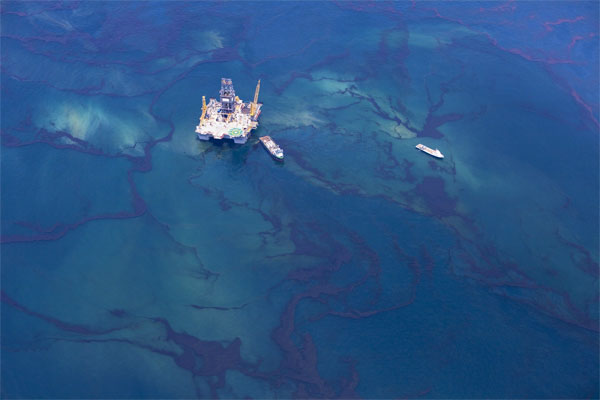 Ships make their way through surface oil past a rig in this aerial view over the Gulf of Mexico May 18, 2010. Fears that ocean currents were spreading oil from the Gulf of Mexico spill flared on Tuesday after tar balls turned up in Florida, raising pressure on energy giant BP to capture more of the leaking crude. [Xinhua] 