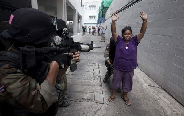 An anti-government &apos;red shirt&apos; supporter surrenders to army soldiers clearing their encampment in Bangkok May 19, 2010.