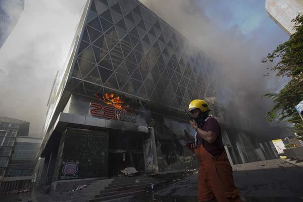 A fireman walks past Central World shopping mall which was set ablaze by anti-government &apos;red shirt&apos; supporters after the military penetrated their encampment in Bangkok May 19, 2010. 