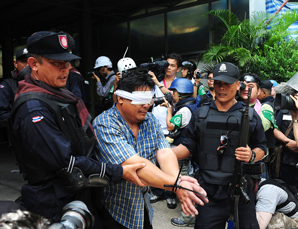 Policemen escort arrested red-shirt protestors in Bangkok, capital of Thailand, May 19, 2010. [Xinhua photo]