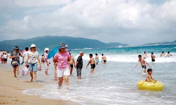 Tourists enjoy themselves in the sea, in Sanya, a popular seaside resort on the southern tip of south China's Hainan Province, May 19, 2010. Local meteorologic bureau issued extremely hot weather alert that parts of the regions of the island, including the provincial capital of Haikou, would be hit by the hot wave, with the peak temperature at 38 degree Celsius. [Xinhua/Jiang Tieying]