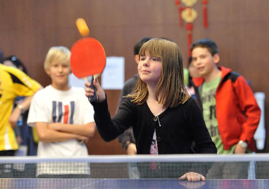 A Belgian girl learns to play Pingpong at the Open Day of the Chinese Mission to the European Union in Brussels, capital of Belgium, May 19, 2010. Some 500 local residents attended the Open Day activity to learn more about China. [Xinhua photo]