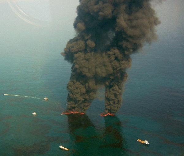 Dark clouds of smoke and fire emerge in the leaking oil area which gushed from the Deepwater Horizon wellhead in this aerial view over the Gulf of Mexico May 20, 2010.[Xinhua] 