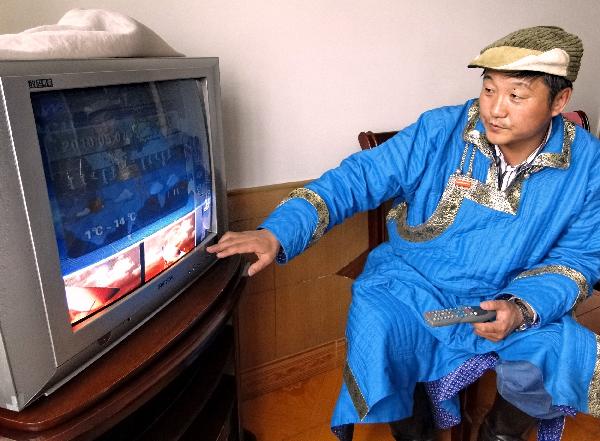 A local herdsman watch TV by using solar and wind power in Dong Ujimqin Qi, Xilingol, north China's Inner Mongolia Autonomous Region, May 8, 2010. [Xinhua/Li Xin]