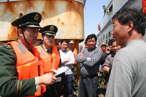 The police inspect a fishing vessel during a patrolling activity in Weihai, east China's Shandong Province, May 20, 2010. [Xinhua] 