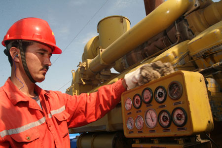 An employee checking meter readings at an oil well in the Xinjiang Uygur autonomous region.