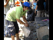 A local resident clear road in front of his house in Bangkok, May 21, 2010.  [Xinhua]