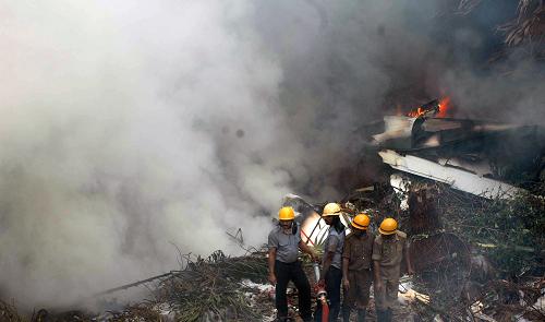 Rescue personnel work at the scene of a plane crash in Mangalore May 22, 2010. The plane from Dubai overshot a runway and crashed outside an airport in southern India on Saturday, killing at least 160 people in one of the worst air accidents in India in years. [Xinhua]