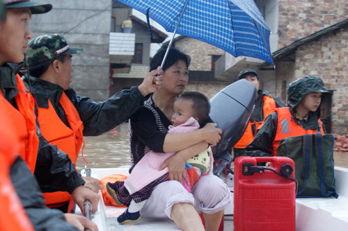 Police officers help transfer local residents out of the flood-plagued city of Xinyu, East China&apos;s Jiangxi province, May 21, 2010.[Xinhua]