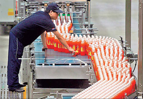 An employee supervises a bottling line at PepsiCo's Chongqing plant. PepsiCo plans to open 14 new plants for soft drinks, non-carbonated beverages and snacks and add production lines in existing facilities.