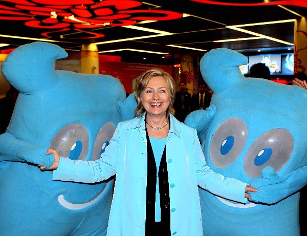 U.S. Secretary of State Hillary Clinton poses for photos with Haibao, mascot of the Shanghai World Expo 2010, during her visit to the China pavilion at the Expo, May 22, 2010. 