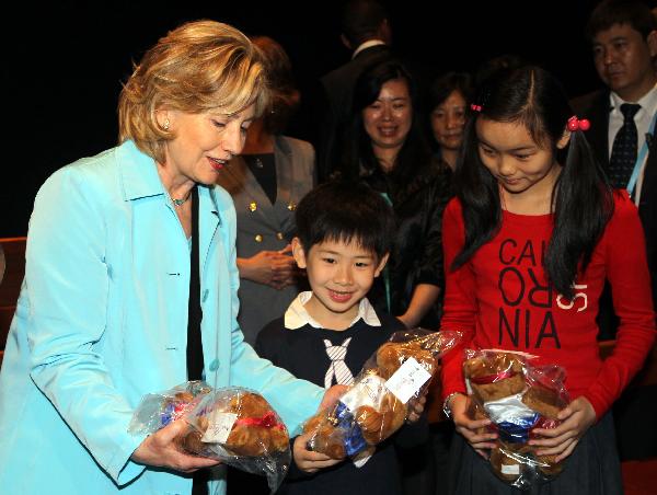 U.S. Secretary of State Hillary Clinton presents gifts to Chinese children during her visit to the United States pavilion at the 2010 World Expo in Shanghai, May 22, 2010.