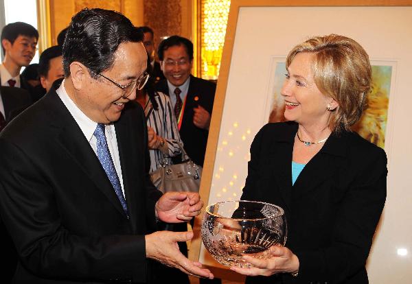 U.S. Secretary of State Hillary Clinton presents a gift to Yu Zhengsheng (L), member of the Political Bureau of the Communist Party of China (CPC) Central Committee and secretary of the CPC Shanghai Municipal Committee, during her visit to the Shanghai World Expo Park in Shanghai, east China, on May 22, 2010.