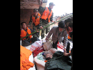 Armed policemen transfer a trapped villager in Xinqiao Village of Shuibei Township in Xinyu City, east China's Jiangxi Province, May 22, 2010. [Xinhua]
