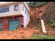 People check the landslide caused by the rainfall recently in Meijie Village of Hanfang Township in Ganxian County, east China's Jiangxi Province, May 23, 2010. [Xinhua]